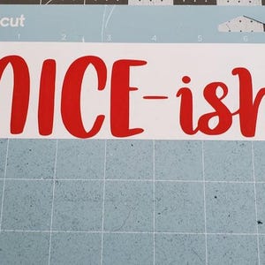 May include: A white sheet of paper with the words "NICE-ish" written in red lettering.