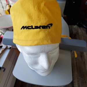 McLaren on yellow fabric scrub hat, black letters/logo and more
