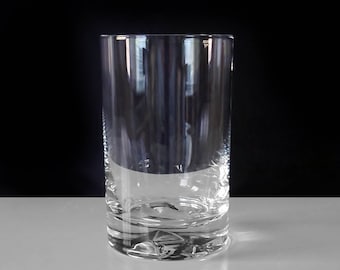 May include: A clear glass tumbler with a textured bottom. The glass is empty and has a cylindrical shape.