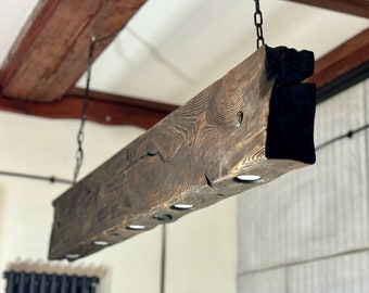 Dark wooden beam lamp hanging on chains in a rustic style. A unique wooden lamp with 5 LED bulbs, handmade