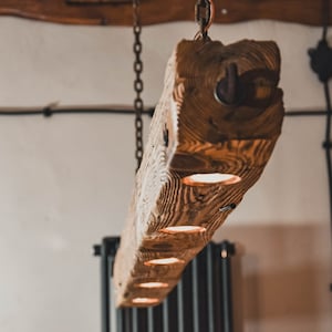 Long wooden beam lamp hanging on chains in rustic style. Unique wooden lamp with 5 LED bulbs handmade