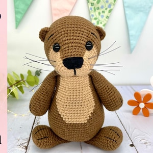 May include: A handmade crochet otter plushie in shades of brown and tan, with black eyes and whiskers. The otter has a light tan belly and is sitting upright. The word "Pattern" is written vertically on the left side of the image. Decorative floral and banner elements are in the background.