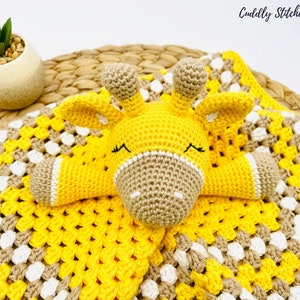 May include: A crocheted yellow and brown giraffe baby blanket with a crocheted giraffe attached. The blanket is made with a granny square pattern.