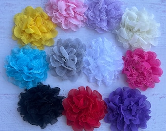 May include: Assortment of 10 handmade fabric flowers in various colors, including yellow, blue, pink, white, gray, red, purple, and black. The flowers are made of soft, ruffled fabric and have a delicate, feminine look.