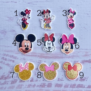 May include: Nine different images of Mickey Mouse and Minnie Mouse characters. The images are printed on white round stickers. The stickers are numbered 1 through 9.