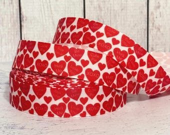 May include: Red and white ribbon with a heart pattern and the words "XOXO", "Love You", "Hug Me", and "Gotta Getta" printed on it.