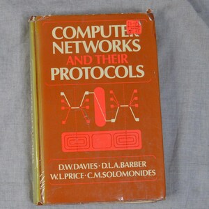 May include: A hardcover book titled Computer Networks and Their Protocols by D.W. Davies, D.L.A. Barber, W.L. Price, and C.M. Solomonides. The cover is orange with cream-colored text and features a graphic illustration of network nodes and lines.