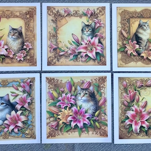 May include: Six cards with ornate gold frames and floral designs featuring cats and lilies. The cats are grey and white with green eyes. The lilies are pink and white with green leaves.