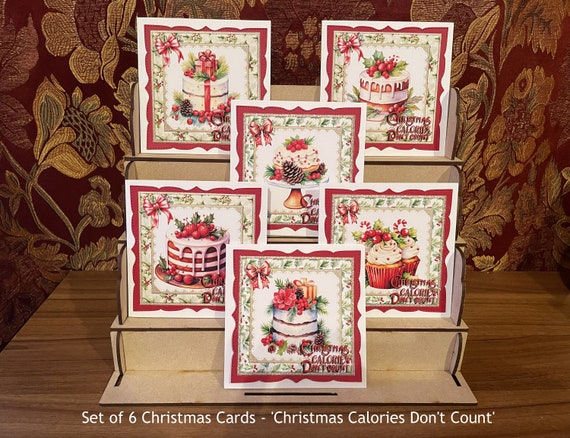 Pack of 6 Different Christmas Cards with cakes and fancy border,  Each with the message ‘Christmas Calories Don’t Count’.