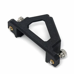 May include: A black, angular bracket with a textured surface. It has a large, open geometric shape in the centre and is secured with silver screws and gold fasteners. The bracket is designed for mounting or support.