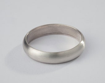 May include: A simple silver wedding band with a brushed finish.