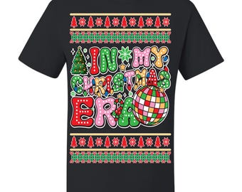 May include: Black t-shirt with a colorful graphic that reads "IN MY CHRISTMAS ERA." The design includes a Christmas tree, a disco ball, and festive text in red, green, and pink. The shirt has a classic crew neck.