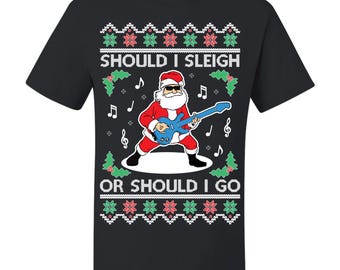 May include: Black t-shirt with a Christmas-themed graphic. The design features Santa Claus playing a blue guitar, with the text "SHOULD I SLEIGH OR SHOULD I GO" above and below the image. The design includes musical notes and festive patterns.