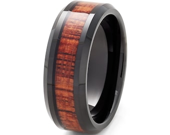 Op de afbeelding: Een zwarte keramische ring met een bruine houten inlay. De ring heeft een afgeschuinde rand en een gepolijste afwerking.