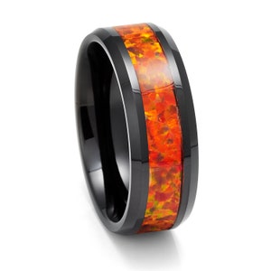 May include: A black tungsten carbide ring with a band of orange and yellow opal inlay.