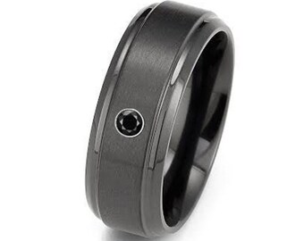 May include: A black brushed metal ring with a single black gemstone set in the center.