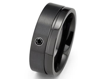 May include: A black tungsten carbide ring with a black diamond inlay and a grooved design.