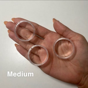 May include: Three clear plastic rings of different sizes, labelled "Medium".