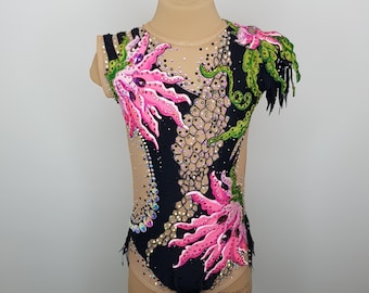 May include: A black leotard with pink and green floral designs. The leotard has a scoop neck and sleeveless design. The leotard is on a mannequin.