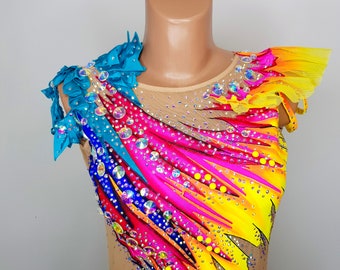 May include: A colorful leotard with a rainbow design and rhinestones. The leotard has a turquoise and yellow fabric trim on the shoulders.