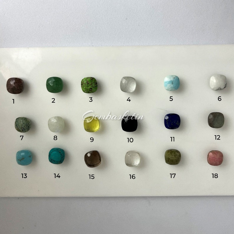 May include: A chart with 18 numbered squares, each containing a different gemstone. The gemstones are arranged in rows of six. The gemstones are various colors, including brown, green, white, blue, black, gray, turquoise, and yellow.