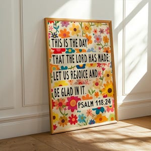 May include: A framed print with a colorful floral background and a quote from Psalm 118:24. The quote reads "This is the day that the Lord has made: Let us rejoice and be glad in it."