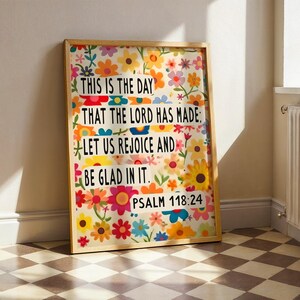 May include: A framed print with a floral design and a quote from Psalm 118:24. The quote reads "This is the day that the Lord has made: Let us rejoice and be glad in it."