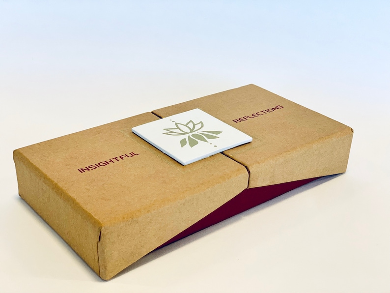 May include: A brown cardboard box with a burgundy trim. The box has a white label with a green lotus flower design and the words "INSIGHTFUL" and "REFLECTIONS" printed on it.