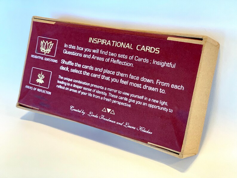 May include: A burgundy box with gold lettering that reads "Inspirational Cards". The box contains two sets of cards: Insightful Questions and Areas of Reflection. The box is designed to help you reflect on your life from a fresh perspective.