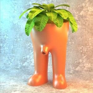 May include: A unique planter shaped like a pair of legs with a green plant growing out of the top. The planter is made of a smooth, orange material.