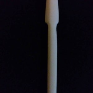 May include: A white plastic spatula with a rounded tip. The spatula is about 10 inches long.