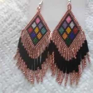 May include: A pair of dangle earrings with a geometric design of colorful squares in the center and a fringe of black and rose gold beads.