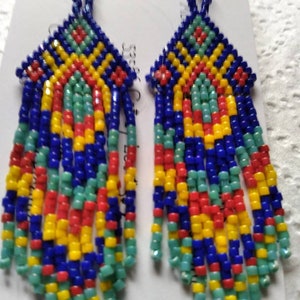 May include: A pair of long, colorful beaded earrings with a geometric pattern. The earrings are made with blue, yellow, red, and green beads.