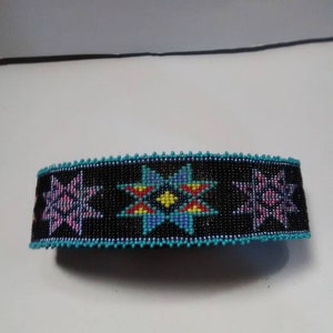 May include: A beaded bracelet with a black background and colorful star designs. The stars are in shades of pink, blue, yellow, red, and green.