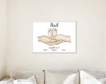 May include: A white framed print with a watercolor illustration of a baby's feet in the palms of two hands. The print includes the name "Naël", the date "28 juillet 2023", and the measurements "36.25", "5kg00", and "52cm".