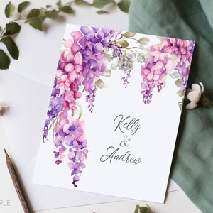 May include: A white card with a watercolor illustration of purple and pink flowers. The text "Kelly & Andrew" is written in black cursive.