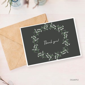 May include: A black card with a white floral wreath and the text "Thank you!" in white script.