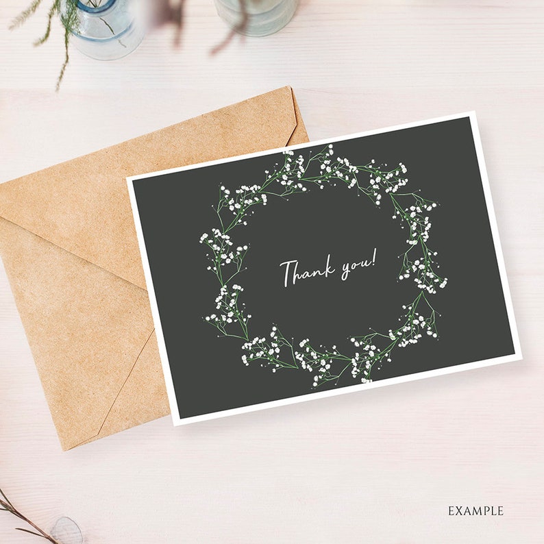 May include: A black card with a white floral wreath and the text "Thank you!" in white script.