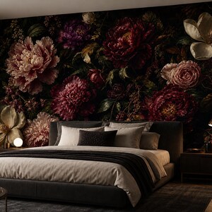 May include: A bedroom featuring a low-profile charcoal gray upholstered bed with light gray bedding and a dark throw blanket, set against a large-scale wall mural depicting dark, moody, oversized blooming peonies and magnolia flowers.