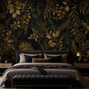 May include: A bedroom featuring a dark wall mural with gold botanical leaf and fern patterns. The bed has a dark gray upholstered headboard, gray bedding, and a dark gray tufted bench at the foot. Two nightstands hold a lamp and decor.