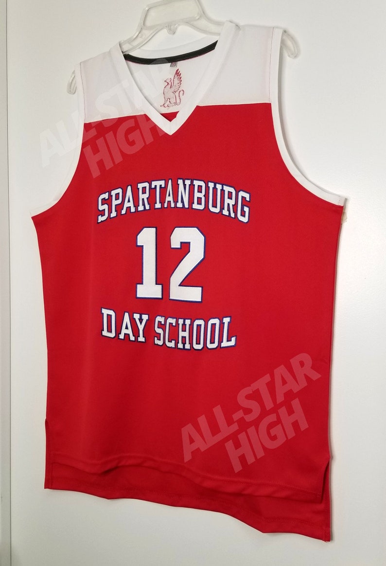 Op de afbeelding: Rood en wit basketbaltenue met de tekst "Spartanburg Day School" en het nummer "12" in wit. Het tenue heeft een witte V-hals en witte afwerking rond de armsgaten.