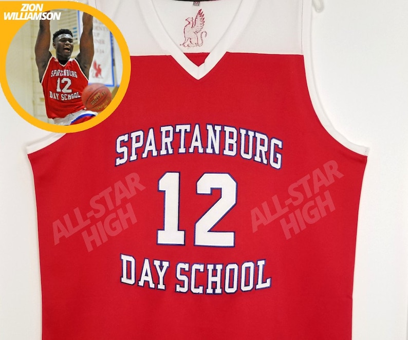 Op de afbeelding: Rood basketbaltenue met witte afwerking en de tekst "SPARTANBURG ALL-STAR HIGH 12 DAY SCHOOL" in witte en blauwe letters.