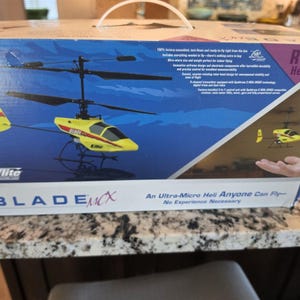 May include: A box for a Blade mCX RTF Heli, a ready-to-fly micro helicopter. The box features a yellow and black helicopter graphic, with the text "An Ultra-Micro Heli Anyone Can Fly - No Experience Necessary."