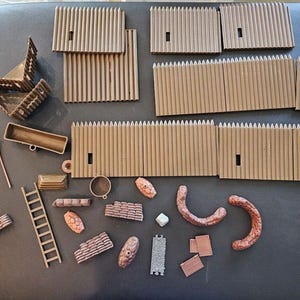 May include: A collection of toy fort pieces, including walls, a fort structure, flags, a ladder, and other accessories. The pieces are primarily brown and tan, with some green and red accents. Perfect for imaginative play.