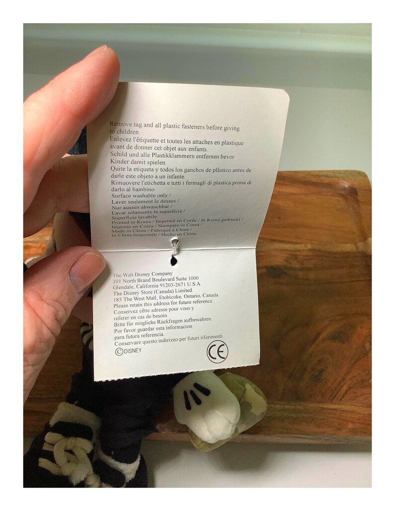 May include: A plush Mickey Mouse hand puppet with white gloves and a black and white striped sleeve. A tag with safety instructions and The Walt Disney Company information is attached.