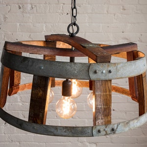 May include: A rustic chandelier made from repurposed wine barrels with a metal band and four light bulbs.