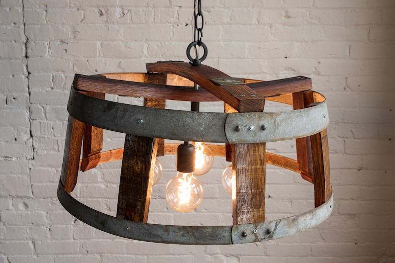 May include: A rustic chandelier made from repurposed wine barrels with a metal band and four light bulbs.