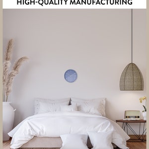 May include: A white bed with a white duvet and two white pillows in a bedroom with a blue clock on the wall and a wicker pendant light hanging from the ceiling.