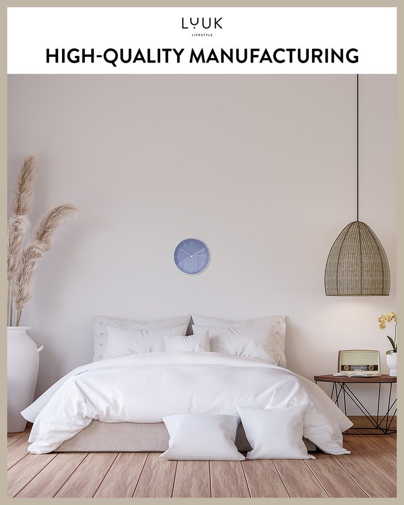 May include: A white bed with a white duvet and two white pillows in a bedroom with a blue clock on the wall and a wicker pendant light hanging from the ceiling.