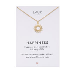 May include: Gold necklace with a sun pendant and a card that reads "Happiness is not a destination. It is a way of life. Put this necklace on, make a wish and your wish will become true."